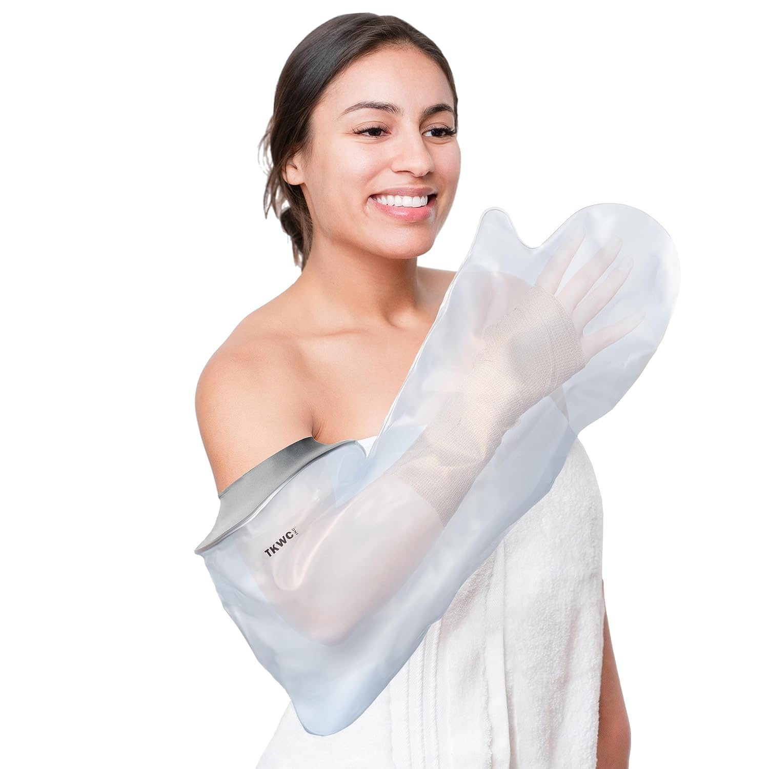 A smiling young woman fitting a transparent waterproof sleeve over her cast-covered left arm.